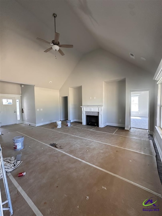 unfurnished living room featuring ceiling fan and high vaulted ceiling