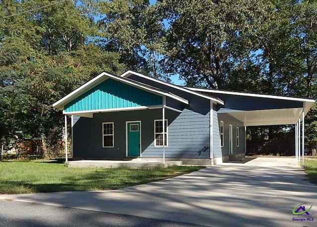 view of front of property with driveway, a carport, and a front yard