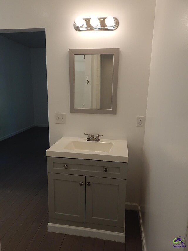 bathroom featuring wood finished floors, vanity, and baseboards