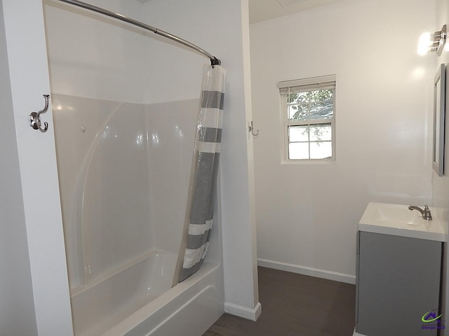 bathroom with shower / bath combo, baseboards, wood finished floors, and vanity