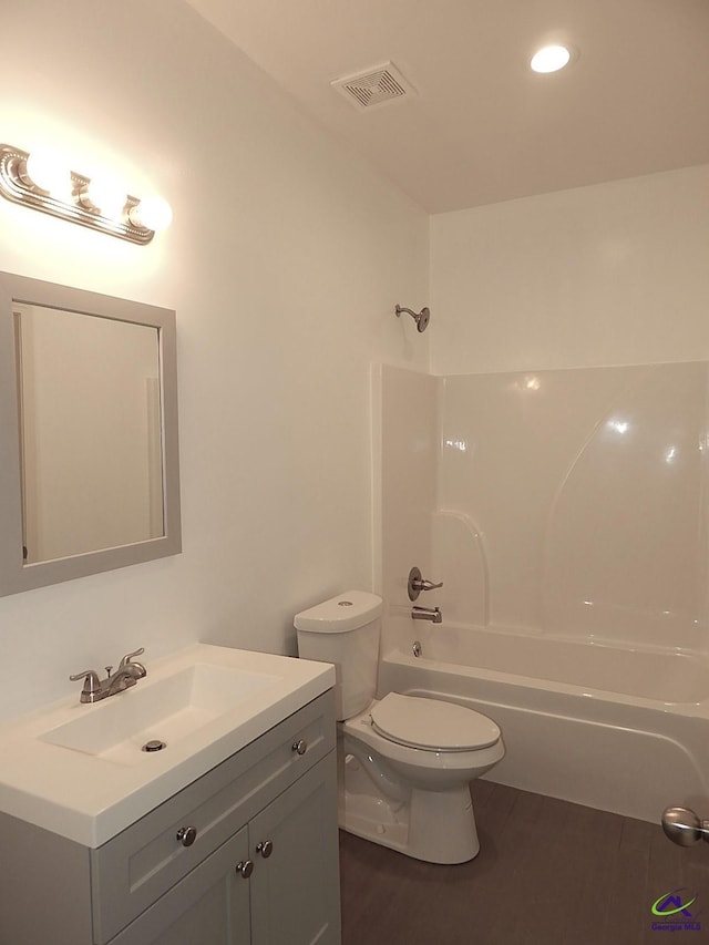 bathroom with shower / washtub combination, visible vents, toilet, vanity, and wood finished floors