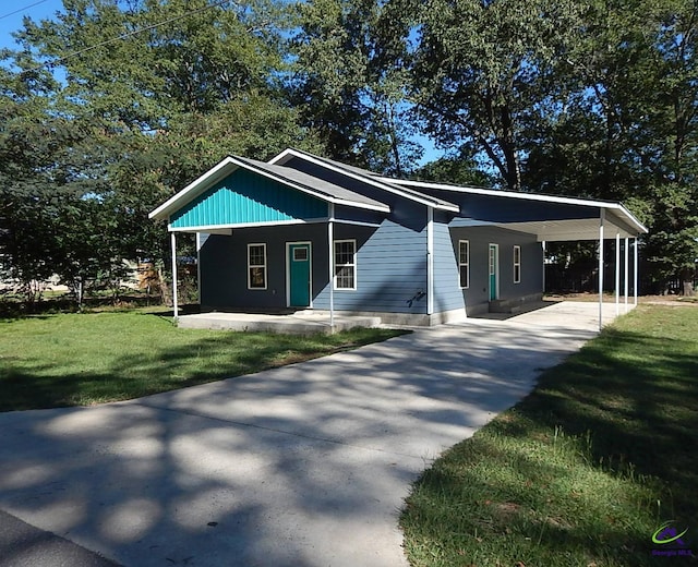 view of front of property with a carport, concrete driveway, and a front lawn