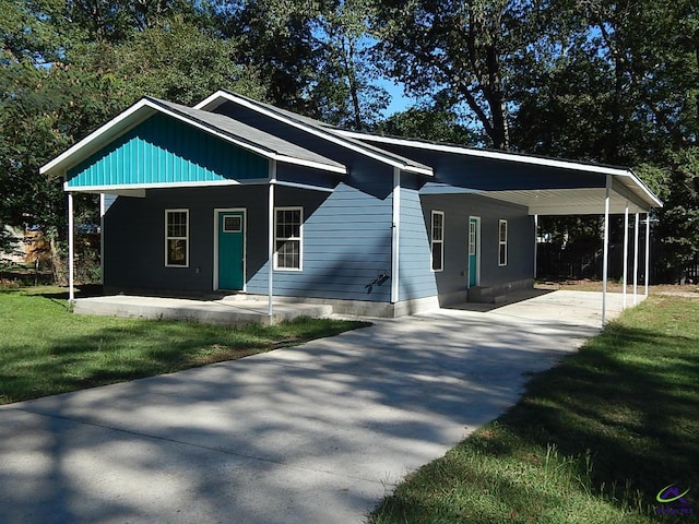 view of front of home featuring a carport, a front yard, and driveway