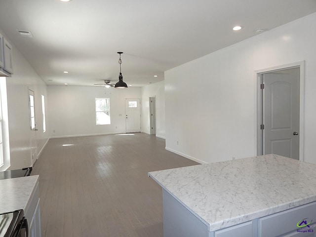 kitchen featuring a center island, recessed lighting, a ceiling fan, wood finished floors, and baseboards