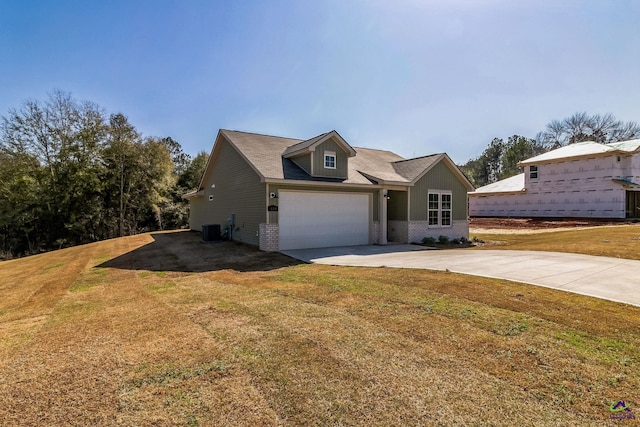 view of front of home with driveway, a front yard, central AC, and brick siding