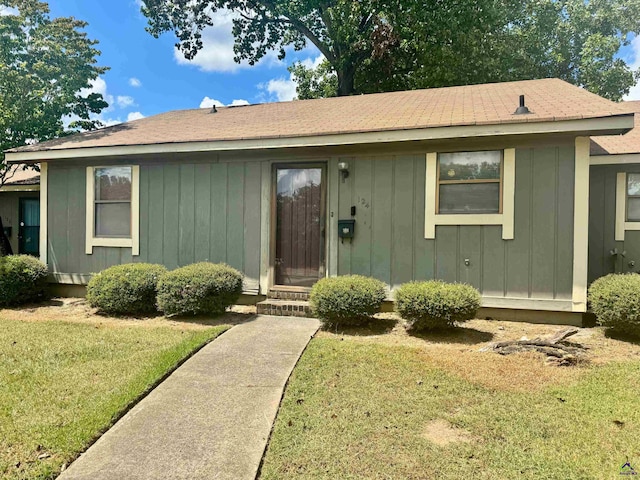 single story home featuring a front lawn