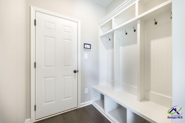 mudroom featuring dark wood-type flooring and baseboards