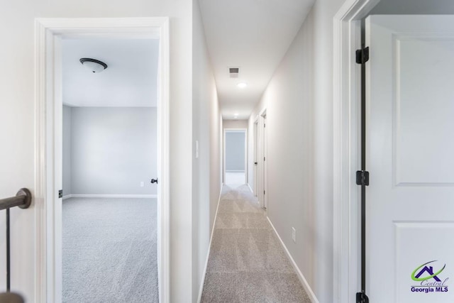 hall featuring visible vents, carpet, and baseboards