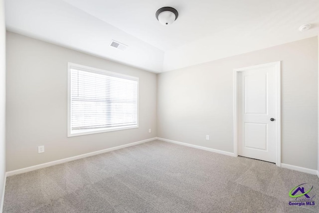 empty room with baseboards, visible vents, and carpet floors