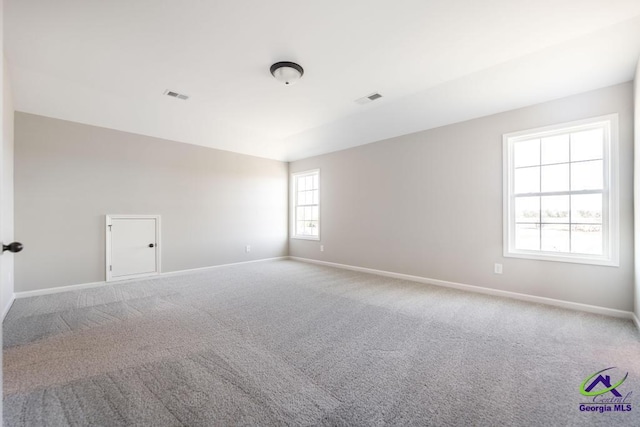 empty room with visible vents, baseboards, and carpet flooring