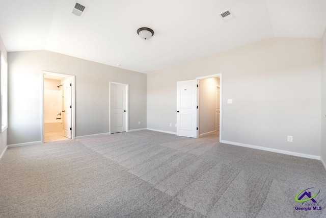 unfurnished bedroom with visible vents, baseboards, carpet flooring, and vaulted ceiling