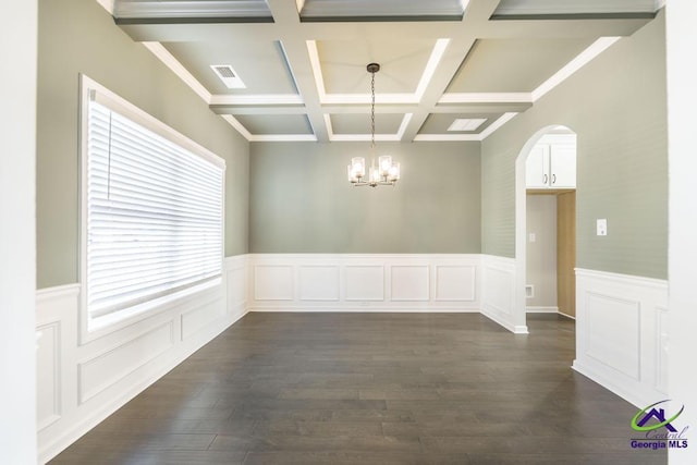 empty room with visible vents, beamed ceiling, a notable chandelier, dark wood-style floors, and arched walkways