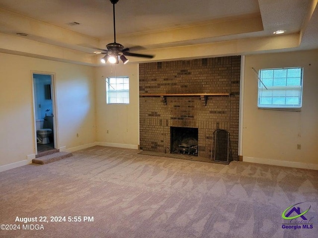 unfurnished living room with ceiling fan, a fireplace, and carpet floors