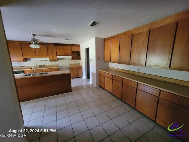 kitchen featuring ceiling fan, light tile patterned floors, and sink