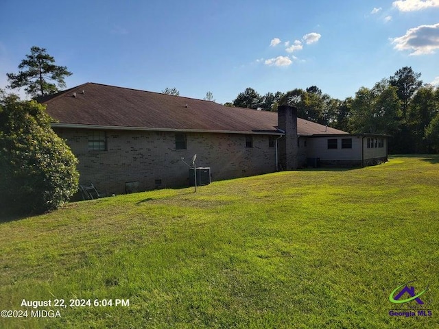 back of house with a yard and central air condition unit