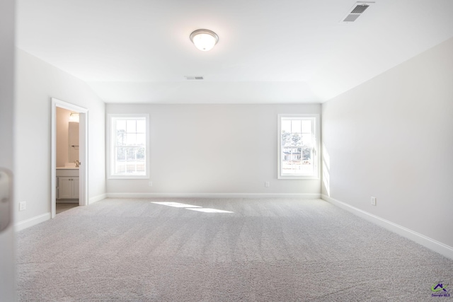 unfurnished room featuring light carpet and plenty of natural light