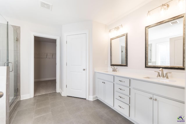 bathroom with tile patterned floors, walk in shower, and vanity