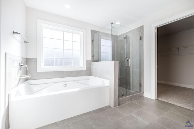 bathroom with tile patterned floors, plus walk in shower, and a healthy amount of sunlight