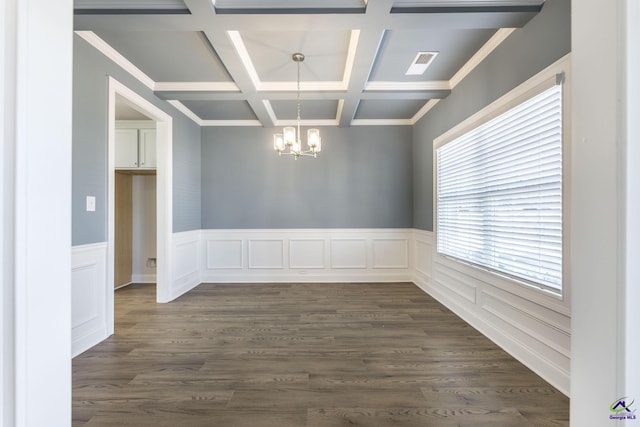 spare room featuring an inviting chandelier, coffered ceiling, dark wood-type flooring, crown molding, and beam ceiling