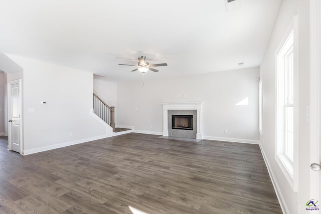 unfurnished living room featuring ceiling fan, a fireplace, and dark hardwood / wood-style floors