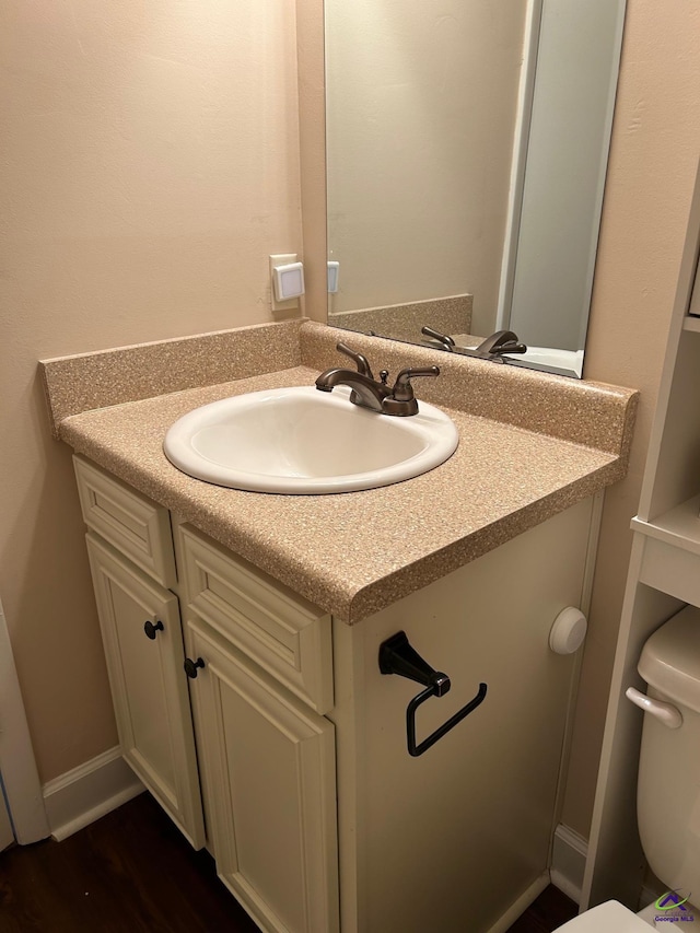 bathroom featuring vanity, toilet, and hardwood / wood-style floors