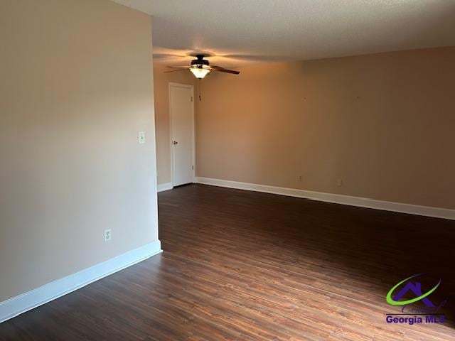 unfurnished room with ceiling fan and dark hardwood / wood-style floors