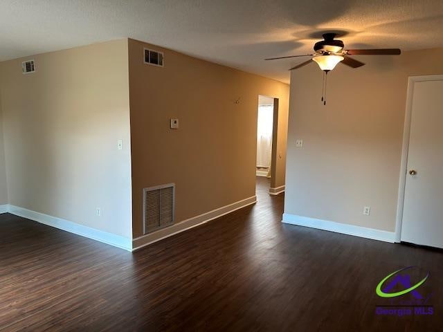 unfurnished room with dark wood-type flooring, a textured ceiling, and ceiling fan