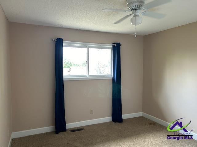 unfurnished room with carpet flooring, ceiling fan, and a textured ceiling