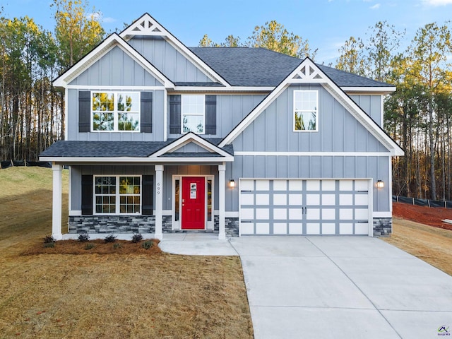699 Jasmine Dr, Macon, GA 31211 - craftsman-style home featuring board and batten siding, driveway, stone siding, a front yard, and roof with shingles