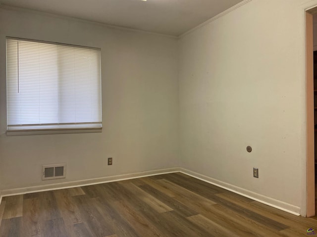 spare room with dark wood-type flooring and crown molding