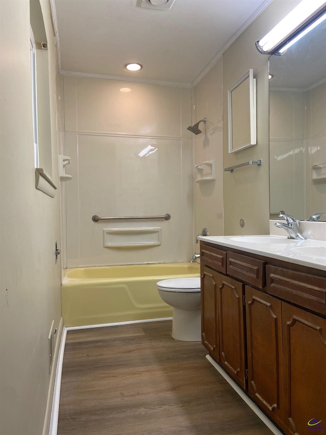 full bathroom with vanity, bathtub / shower combination, hardwood / wood-style flooring, crown molding, and toilet