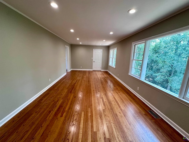 unfurnished room featuring ornamental molding and hardwood / wood-style flooring