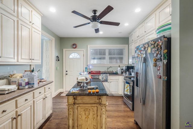 kitchen with a kitchen island, stainless steel appliances, hardwood / wood-style floors, and ceiling fan