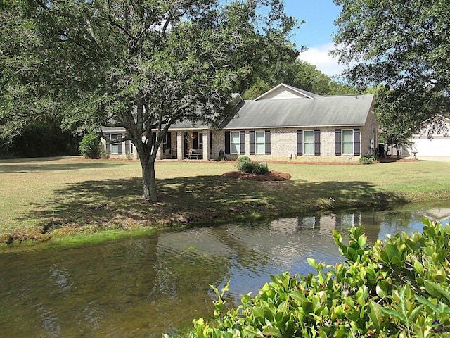 view of front of property featuring a front lawn and a water view