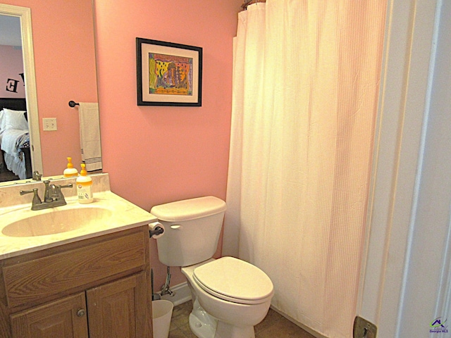 bathroom featuring tile patterned flooring, curtained shower, vanity, and toilet