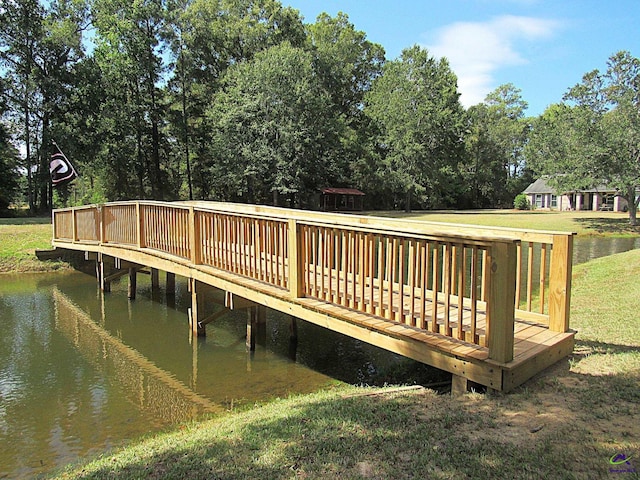 dock area featuring a yard and a deck with water view