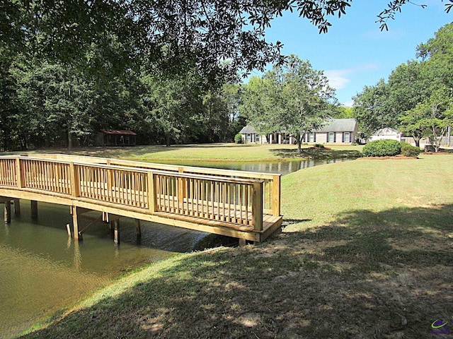 dock area featuring a lawn and a deck with water view