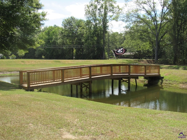 view of dock featuring a yard and a deck with water view