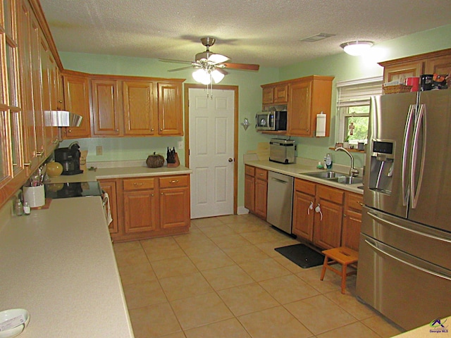 kitchen featuring ceiling fan, light tile patterned flooring, sink, a textured ceiling, and stainless steel appliances