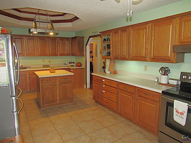 kitchen featuring a raised ceiling, a kitchen island, stainless steel appliances, a textured ceiling, and ventilation hood