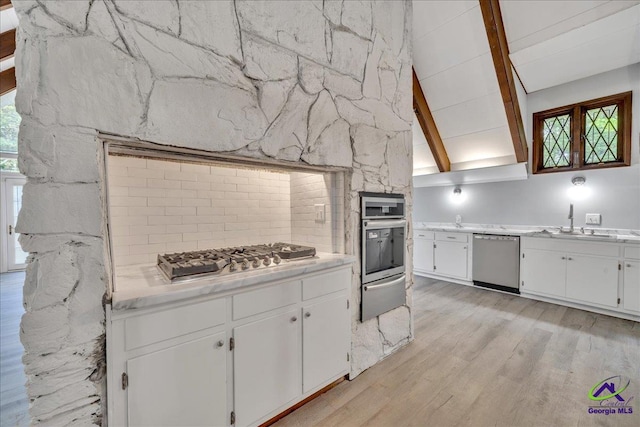 kitchen with sink, appliances with stainless steel finishes, light wood-type flooring, and white cabinets