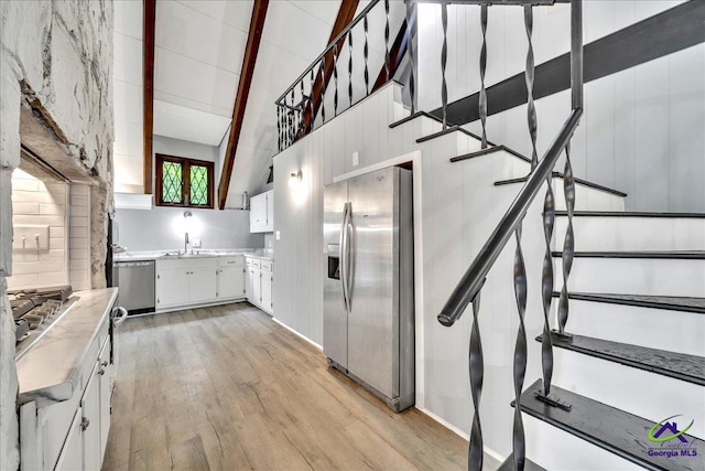 kitchen featuring white cabinetry, appliances with stainless steel finishes, sink, and light wood-type flooring