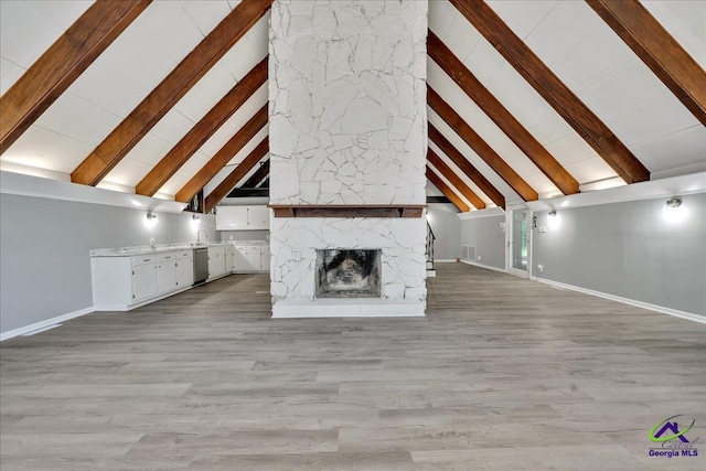 unfurnished living room with light hardwood / wood-style flooring, beam ceiling, high vaulted ceiling, and a fireplace