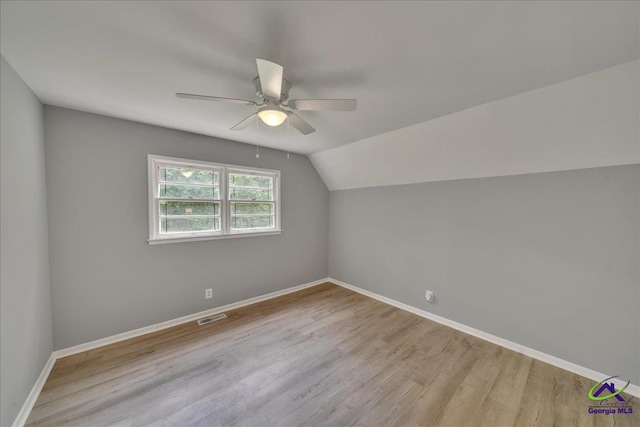 additional living space with vaulted ceiling, light hardwood / wood-style flooring, and ceiling fan