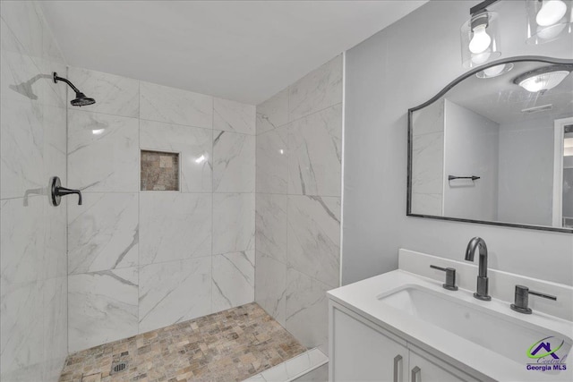 bathroom featuring a tile shower and vanity