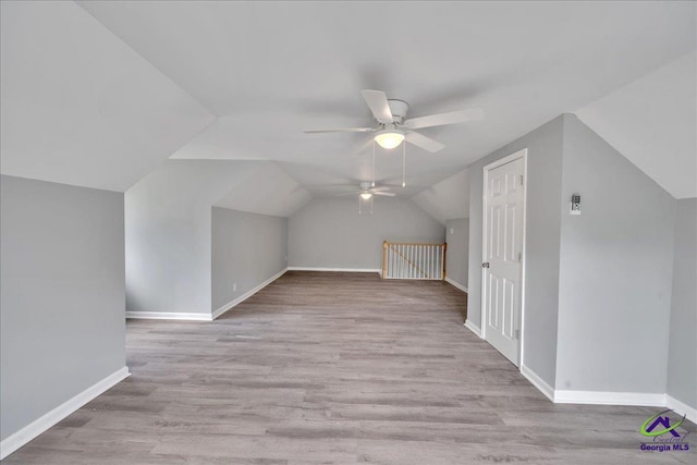 additional living space with vaulted ceiling, light hardwood / wood-style flooring, and ceiling fan