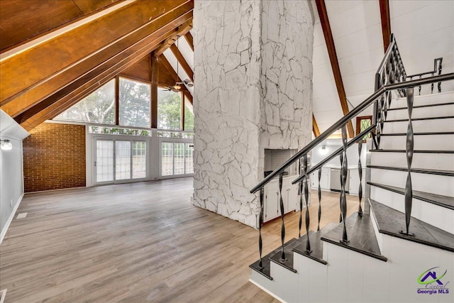 interior space featuring beam ceiling, hardwood / wood-style flooring, and high vaulted ceiling