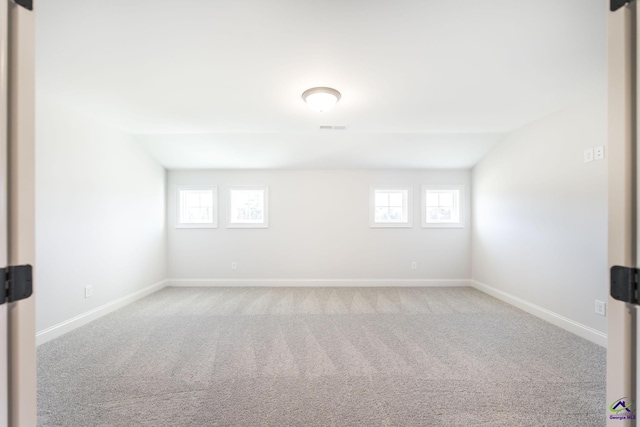 carpeted empty room with plenty of natural light and lofted ceiling