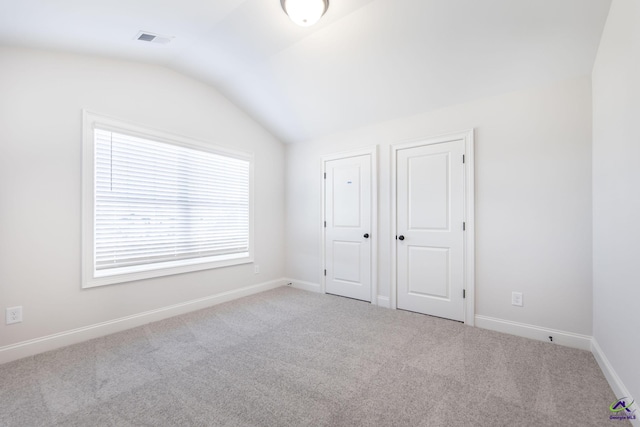 unfurnished bedroom with lofted ceiling and light colored carpet