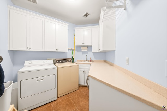 laundry area with light tile patterned floors, sink, cabinets, and separate washer and dryer